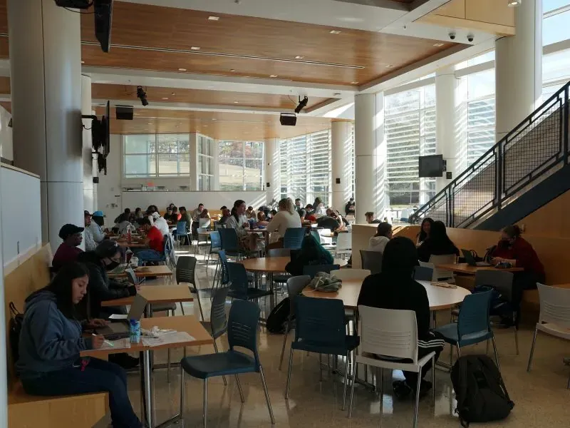 Students sitting around tables inside the cafeteria